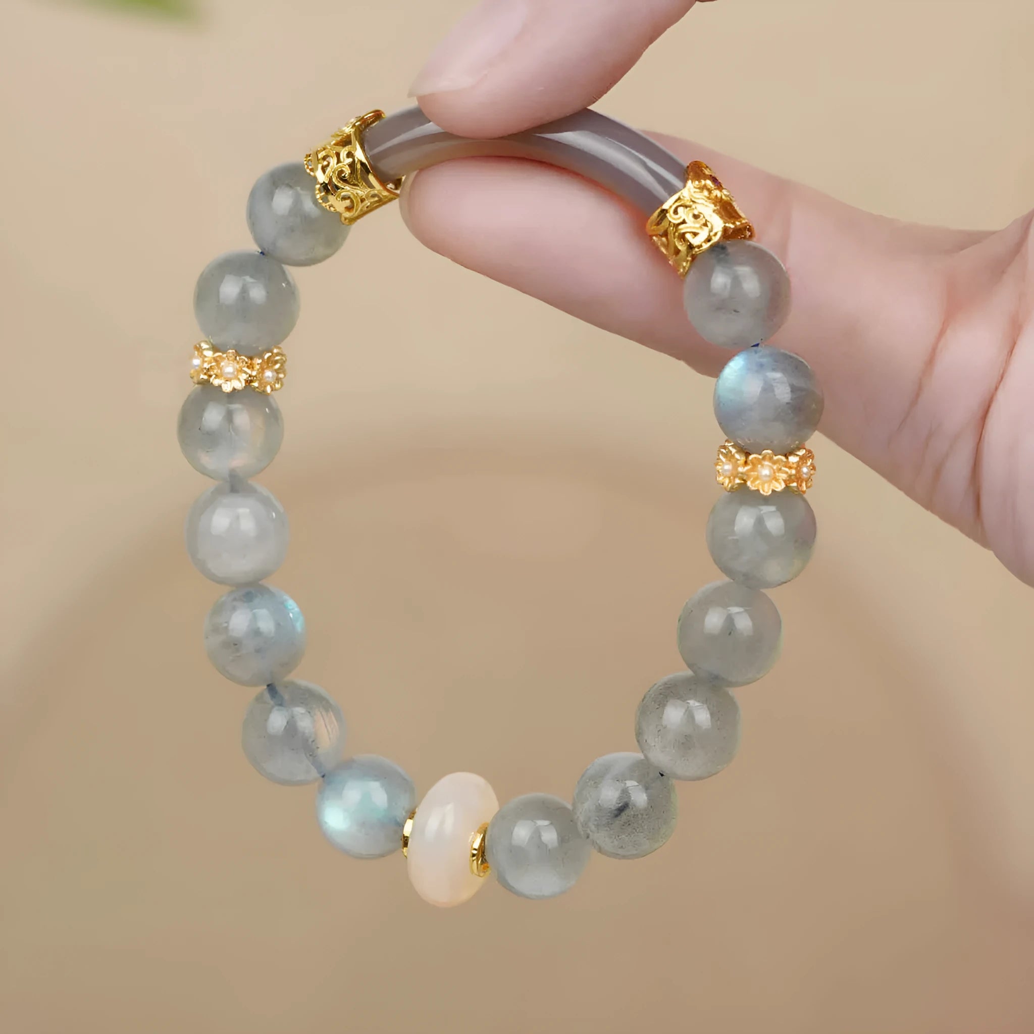 Grey moonstone agate half-wrap bracelet with 8mm round beads on a woman's wrist.