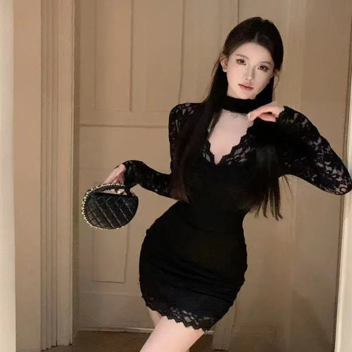 Women's black halter neck lace dress with floral pattern and integrated hip-wrap skirt.