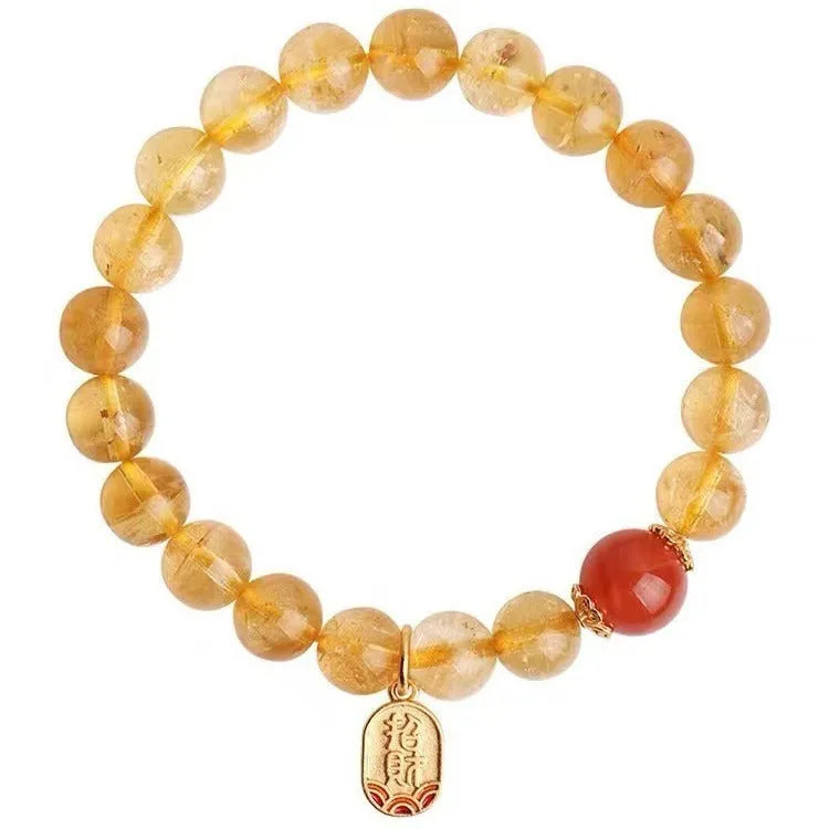 Natural red agate and gold ruby bead bracelet on a wrist, showing polished stones.