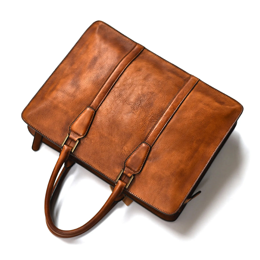 Men's brown leather horizontal business handbag with zippered closure on wooden surface