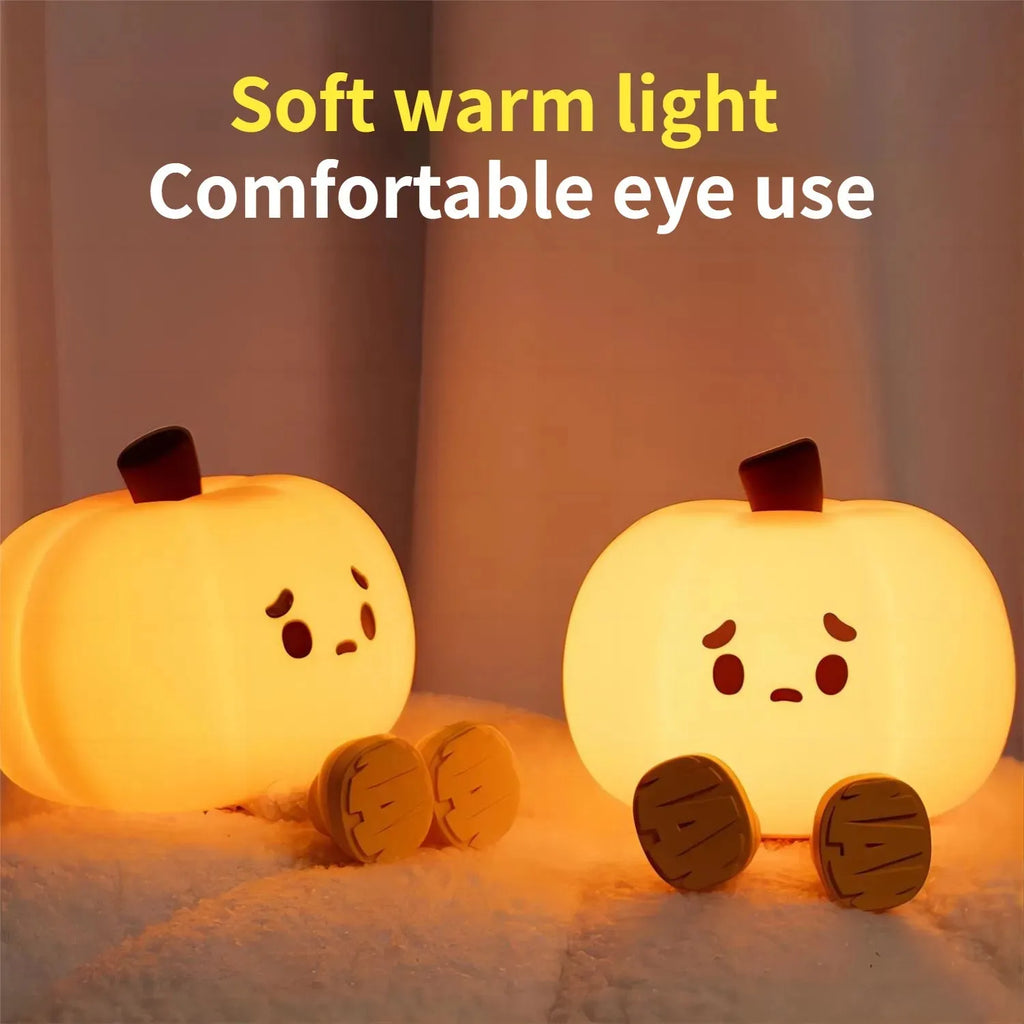 Soft orange silicone pumpkin-shaped night light with a warm glow on a bedside table.
