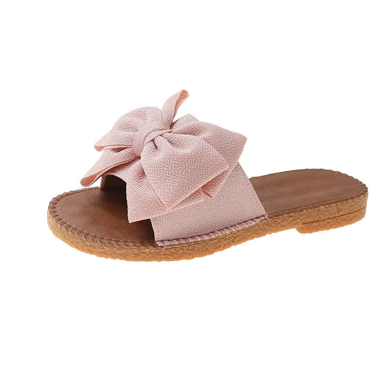 Women's beige suede sandals with bow detail and flat rubber soles