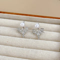 Silver ladies backward-hanging wing pearl earrings with diamond setting on alloy base