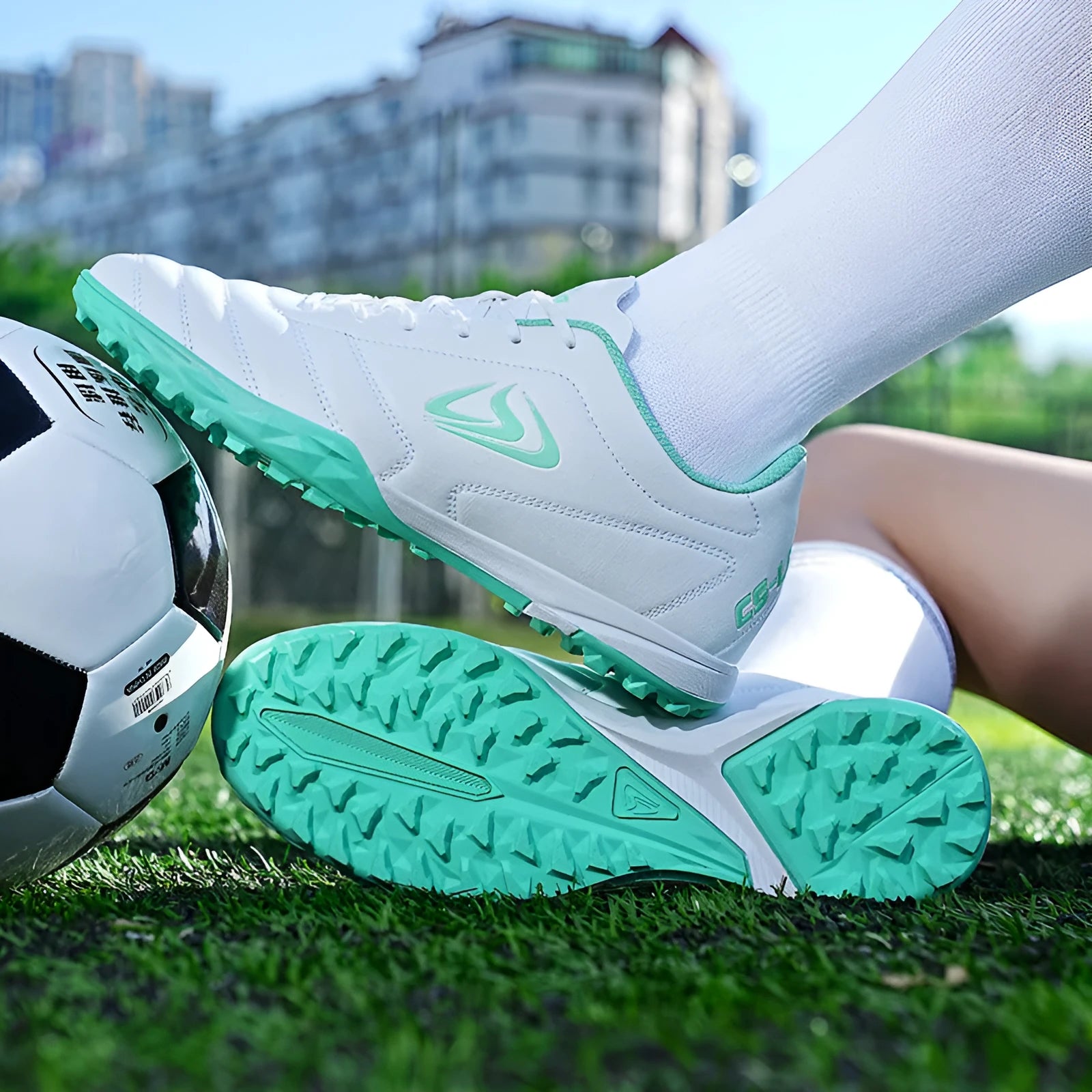 Low-top outdoor soccer shoes in a broken nail colour pattern with a rubber sole and lace-up front.