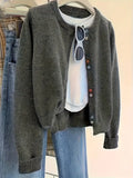 Dark grey women's button-front cardigan with long sleeves on a hanger.