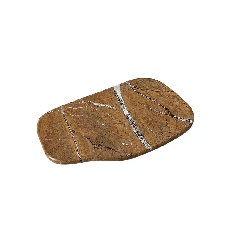 Irregular art marble tray in coffee colour on a wooden table with a plant