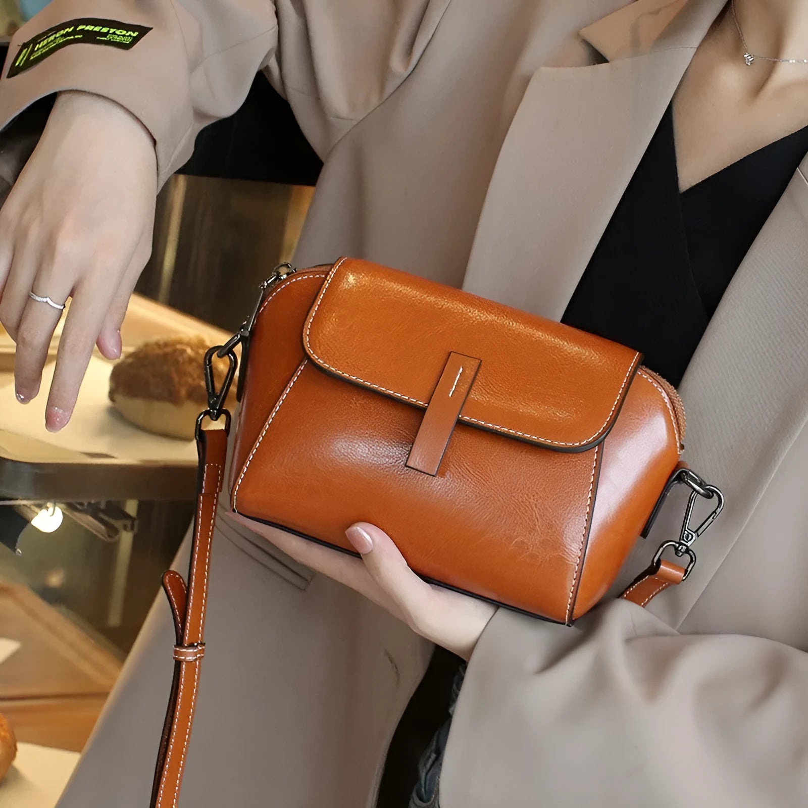 Brown genuine oil wax leather women's messenger bag with crossbody strap and sewing line detail.