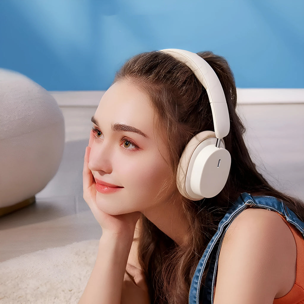 Beige and grey Bluetooth over-ear headphones with a Type-C charging cable on a table.