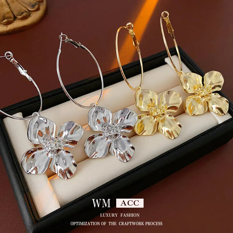 Geometric metal flower earrings with silver needle detail in gold or silver electroplated finish.