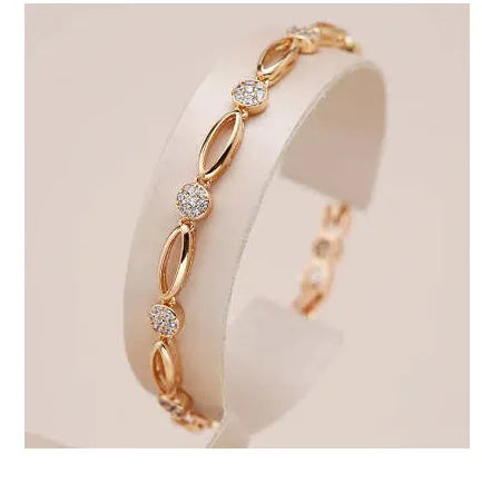 Golden hollow carved copper bracelet in a U-shape for women, showing detailed openwork design.