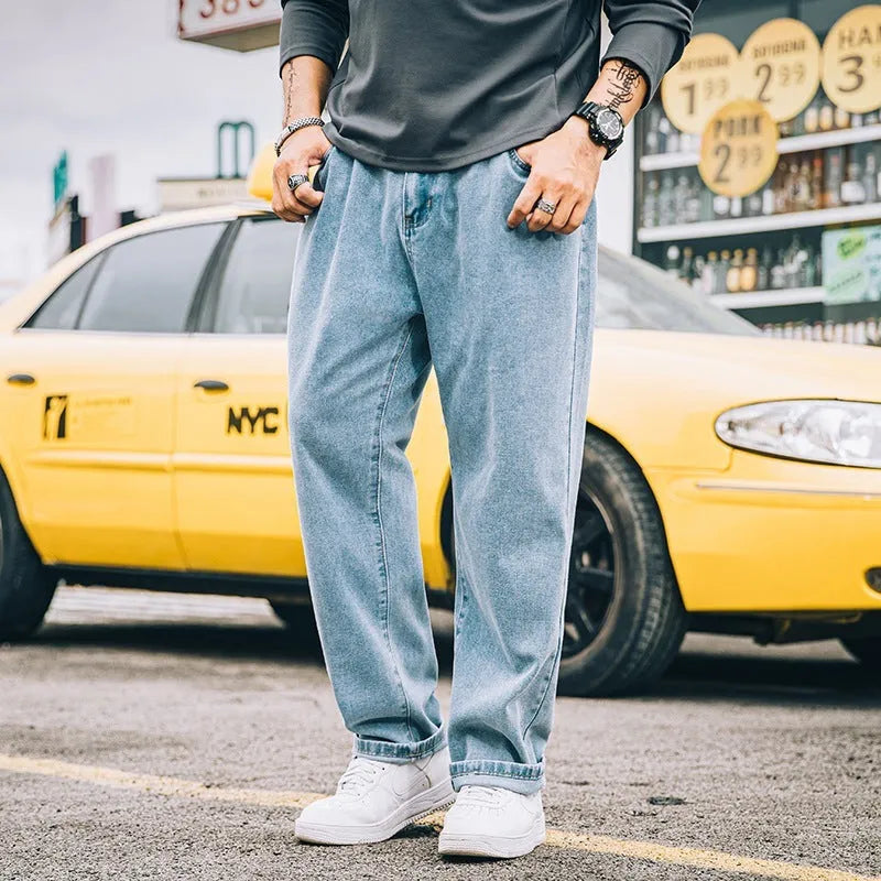 Men's loose straight blue jeans on hanger showing relaxed leg cut and zipper fly