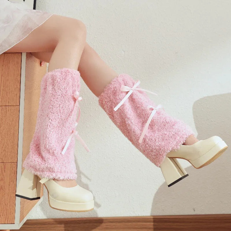 Plush polyester leg warmers with bow detail in black, pink, or grey, average size for youth.