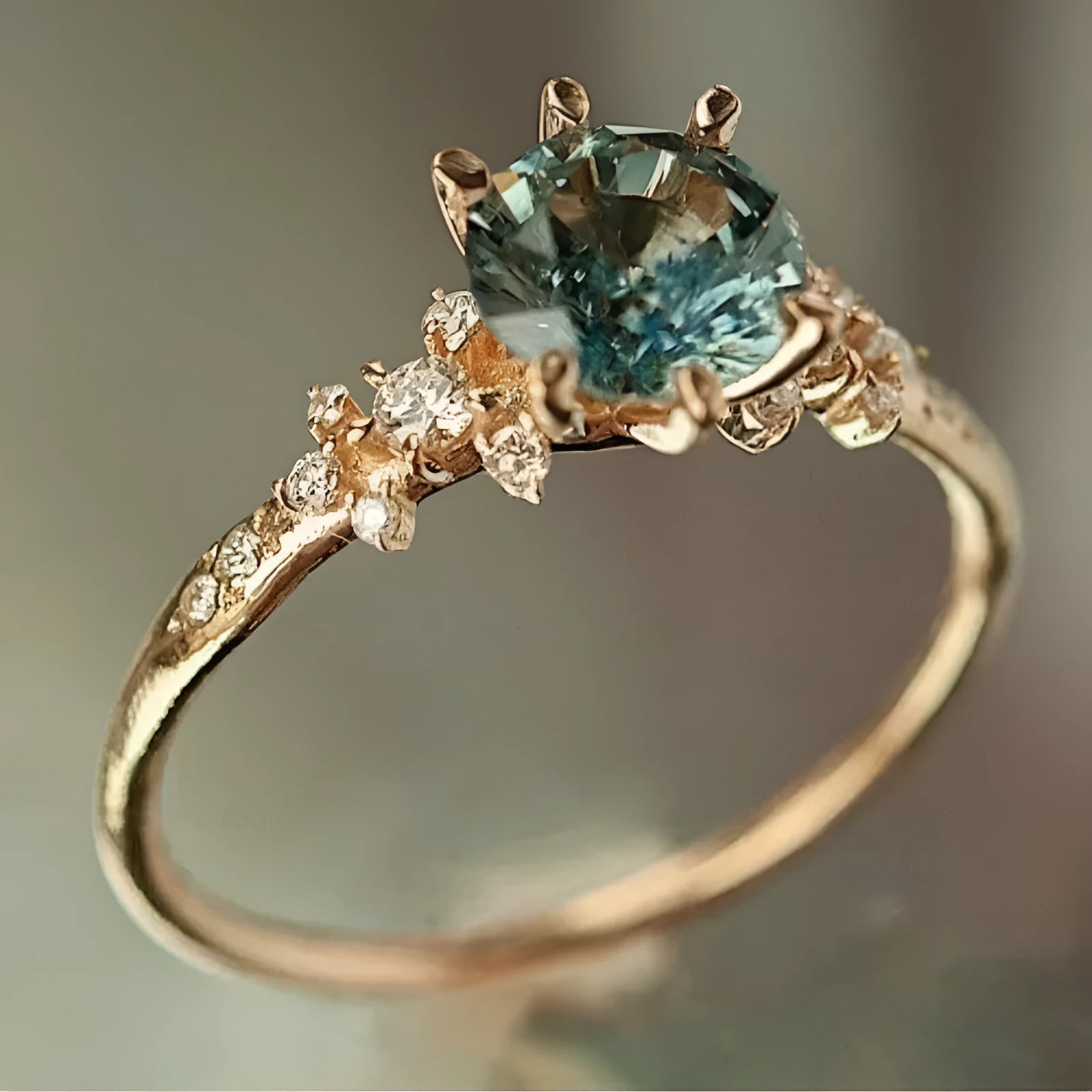 Gold plated claw ring with a central zircon stone and geometric square pattern.