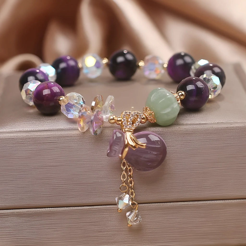 Women's purple Tigereye pendant crystal bracelet with rhinestones on a forest-style background.