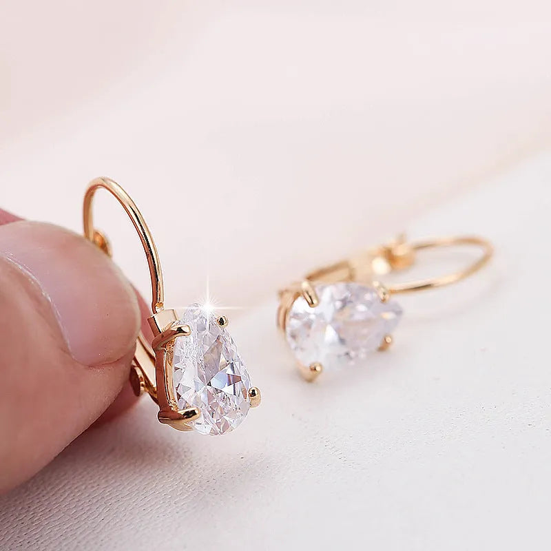 Gold and platinum drop earrings with a cubic zirconia stone set in a simple metal design.