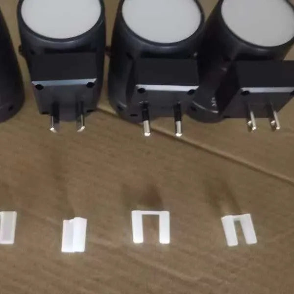 Small white induction night lamp with adjustable brightness and rotatable light head plugged into wall socket