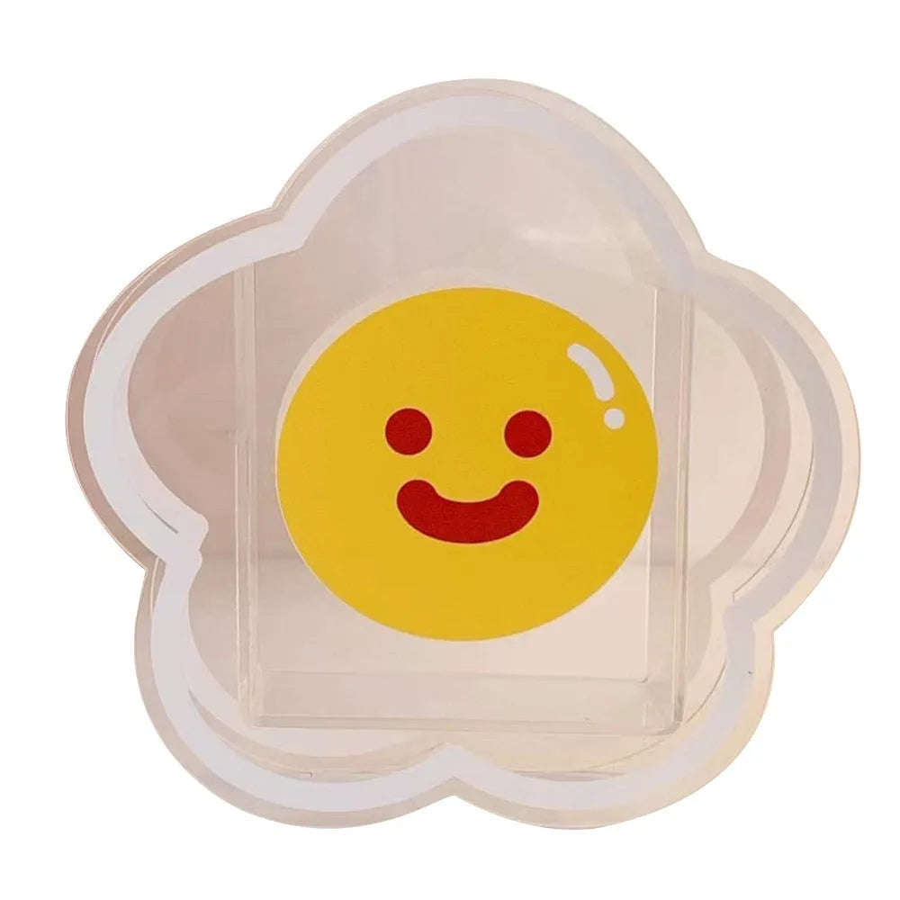 Square clear acrylic storage box with a colourful printed design, used to hold pens and stationery on a desk.