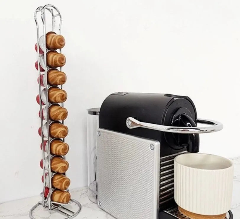 Black wrought iron coffee capsule storage rack displaying pods on a kitchen worktop.