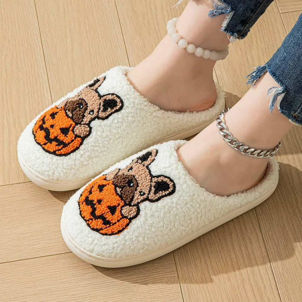 Black and white Halloween slippers with pumpkin pattern, plush lining, and textured non-slip rubber soles.