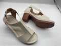 Womens beige Roman style wedge sandals with open peep toe and silver buckle strap on a low heel.