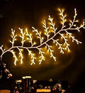 Flexible LED willow vine light garland with warm white lights shaped on a rustic wood background.