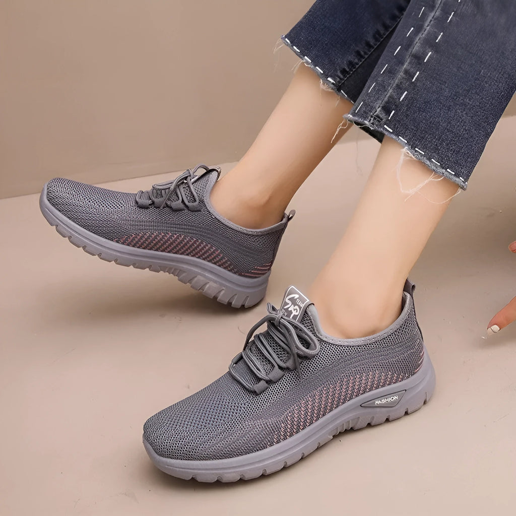 Women's black mesh sneakers with a cross-strap design and round toe, shown on a white background.