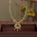 Green women's bracelet with traditional Chinese xiangyun lock pendant and safety closure