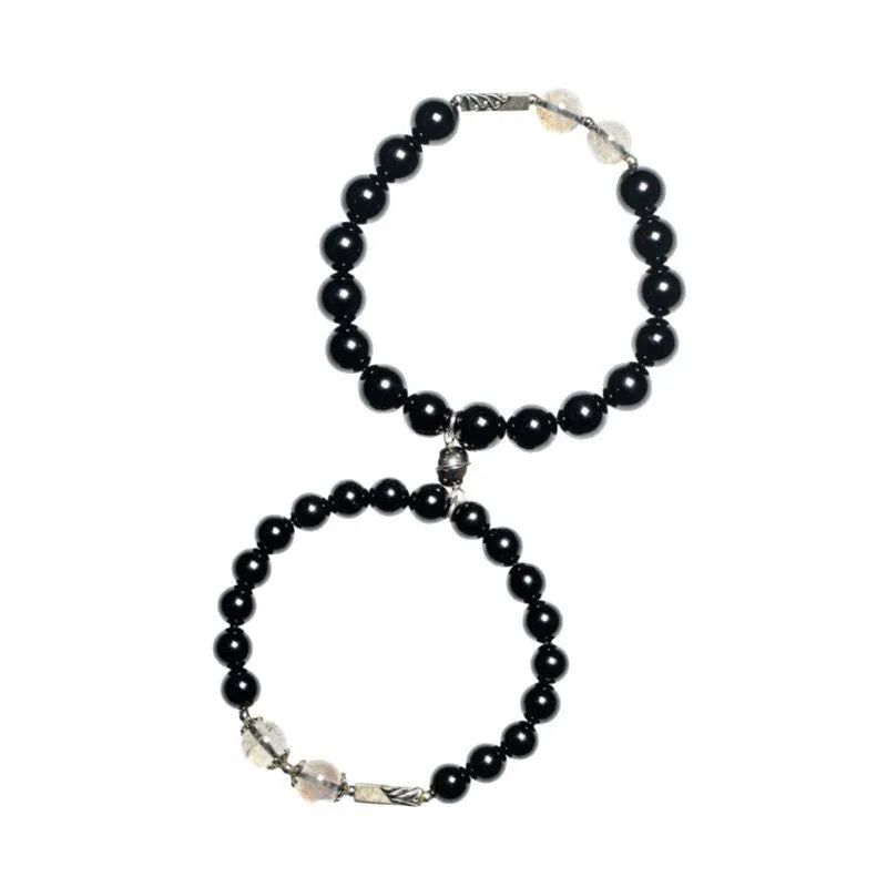 Black obsidian Buddha bead couple bracelets showing 8mm and 10mm sizes on a background.