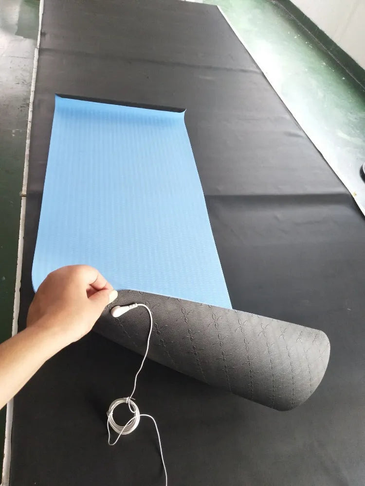 Blue yoga mat with plant patterns, showing grounding wire and non-slip texture.