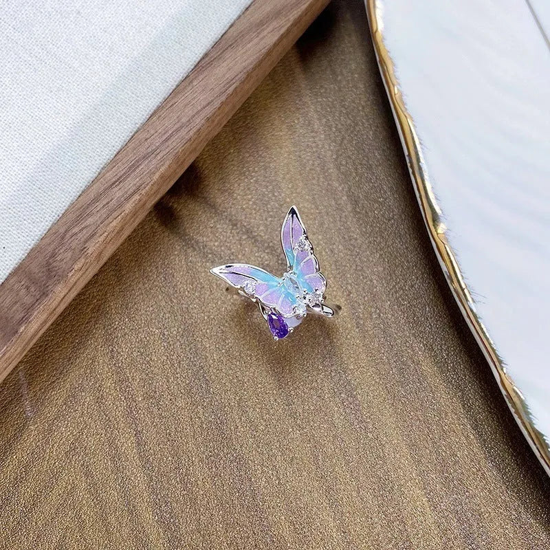 Close-up of an adjustable, irregularly shaped copper ring featuring a detailed insect motif.