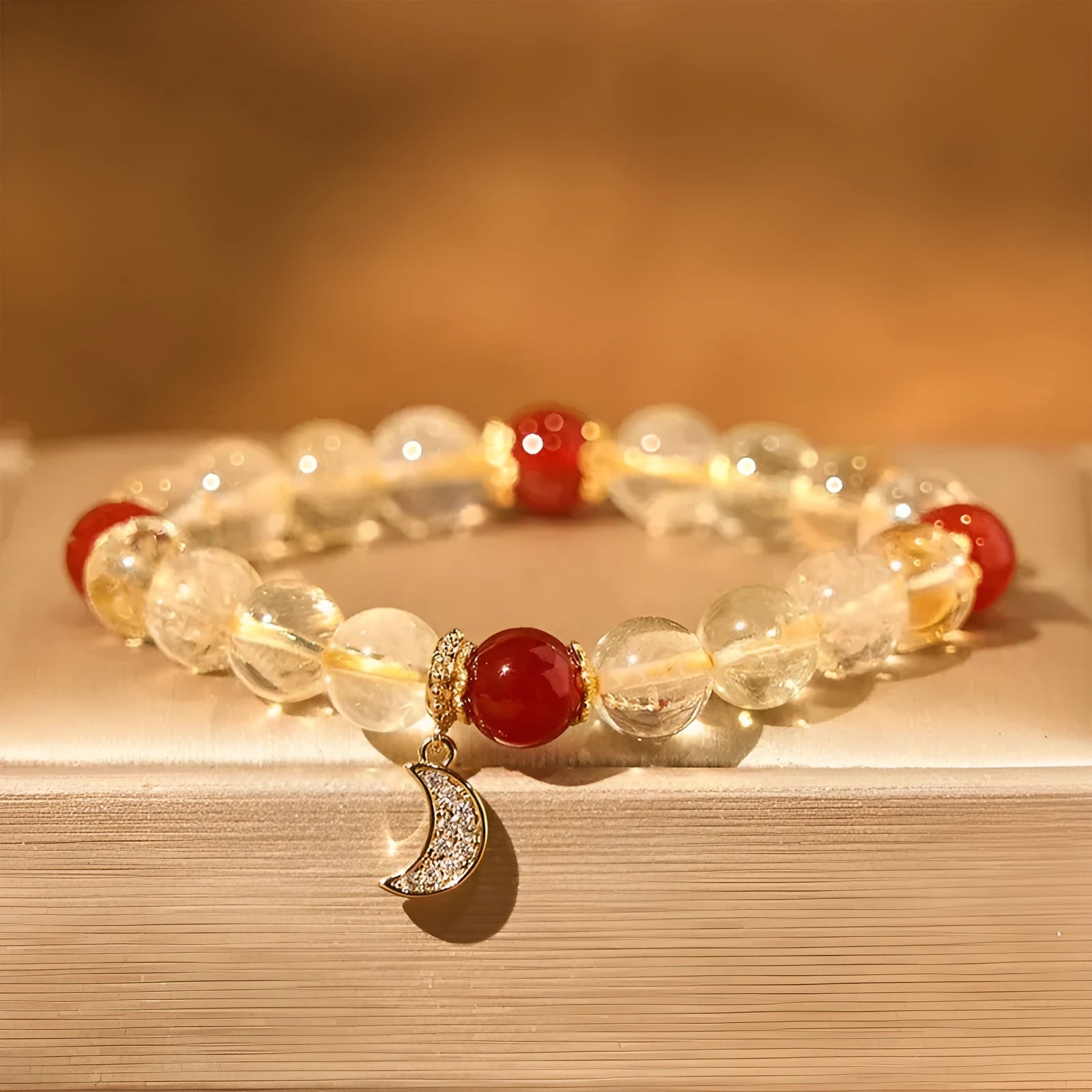 Citrine and red agate crystal moon boom bracelet for women on a white background.