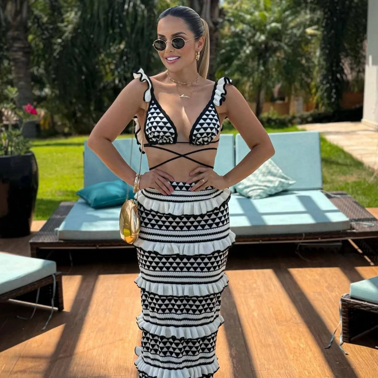 Black and white striped women's bikini set with ruffled spaghetti strap top and long knitted skirt.