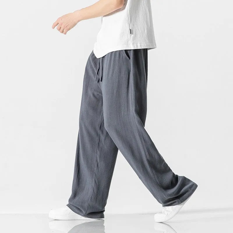 Man wearing beige cropped straight-leg linen trousers with a drawstring waist.