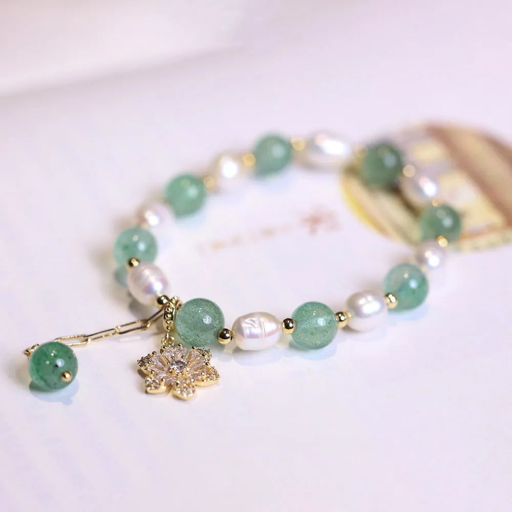 Green geometric strawberry freshwater pearl bracelet with small flower charm and Chinese knot design.