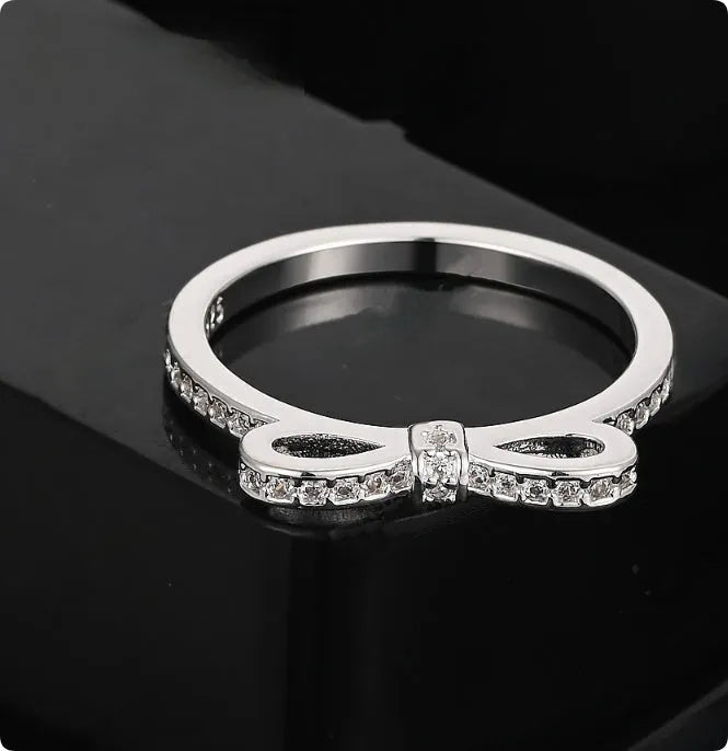 Silver-coloured fashion ring with a bow design adorned with clear zircon crystal stones.