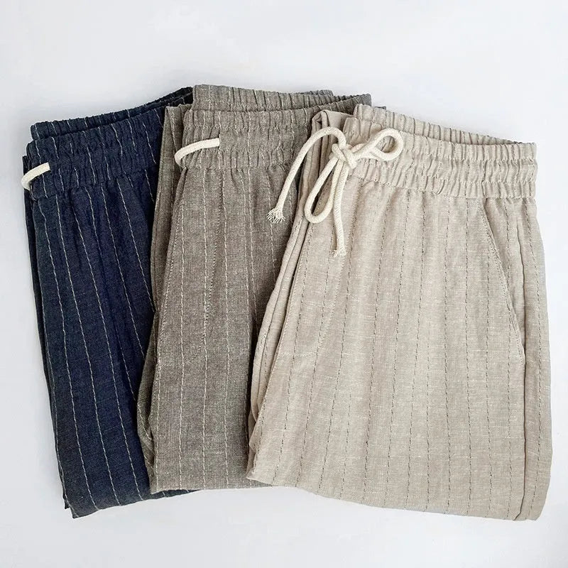 Man wearing beige striped cropped casual cotton-linen trousers on a summer day.