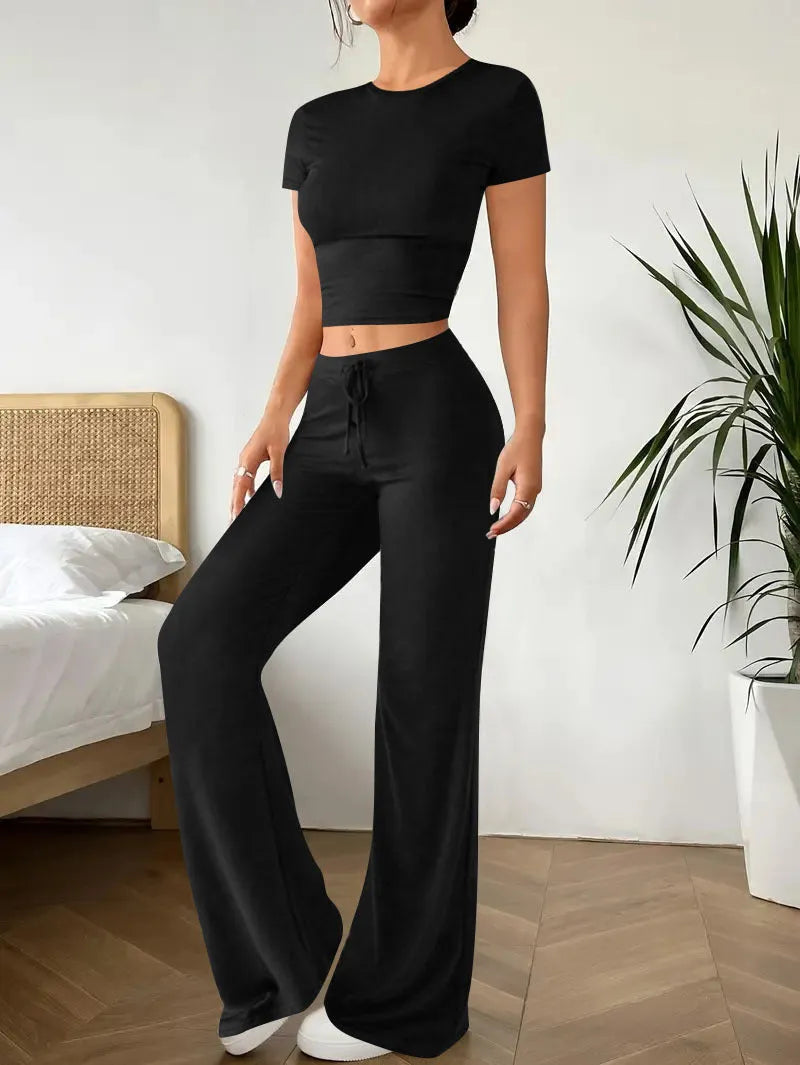 Black high-waist trousers and matching short-sleeve t-shirt set on a hanger.