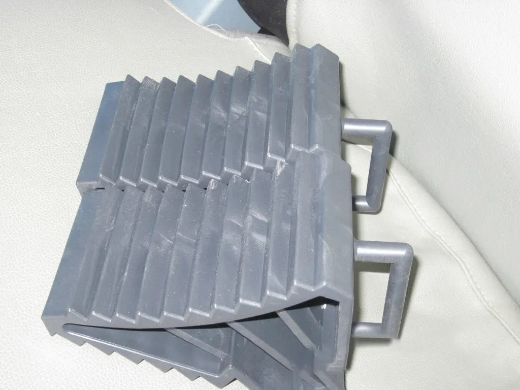 A pair of black triangular car wheel chocks for anti-slip parking safety.