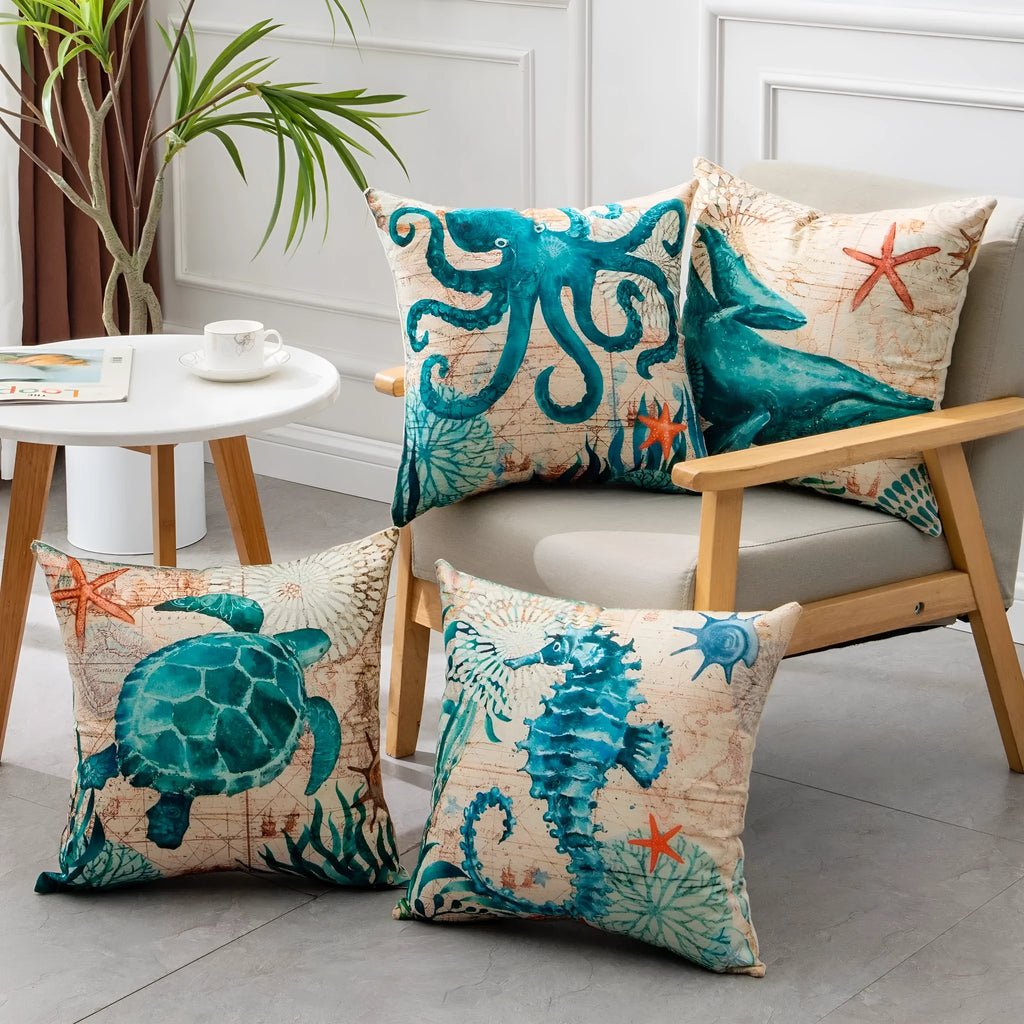Square linen cushion cover with a detailed blue and green sea turtle print, shown on a grey sofa.