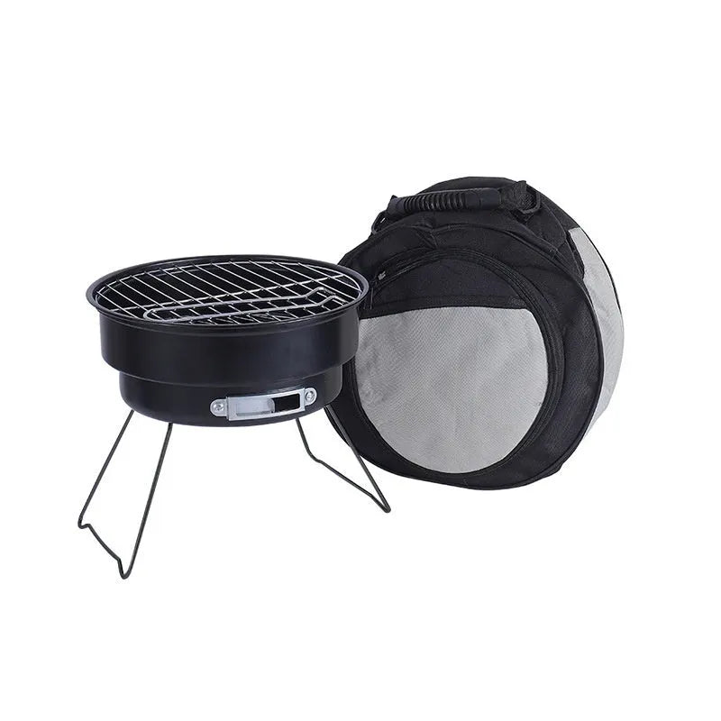 Small, round, folding metal ice stove grill with mesh top and legs, set up for outdoor use.