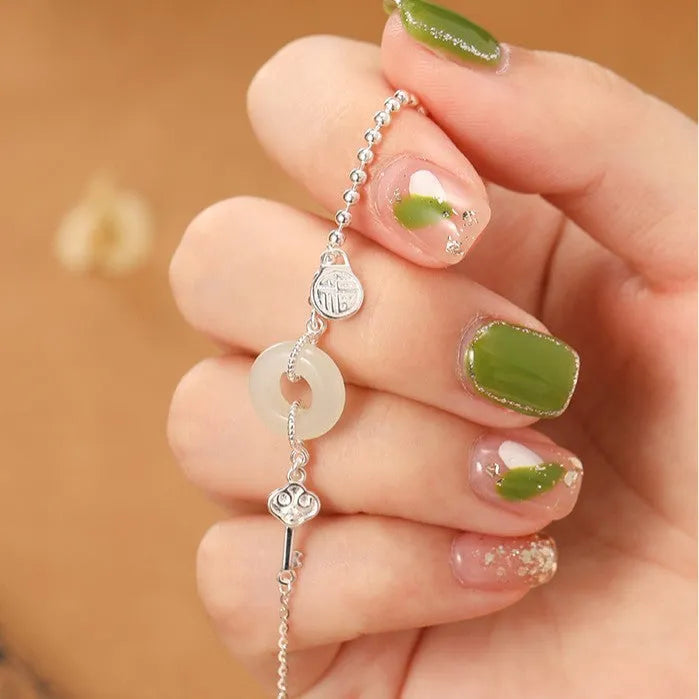 Silver Hetian jade bracelet with peace buckle charm and Chinese Ruyi Xiaofu design for women