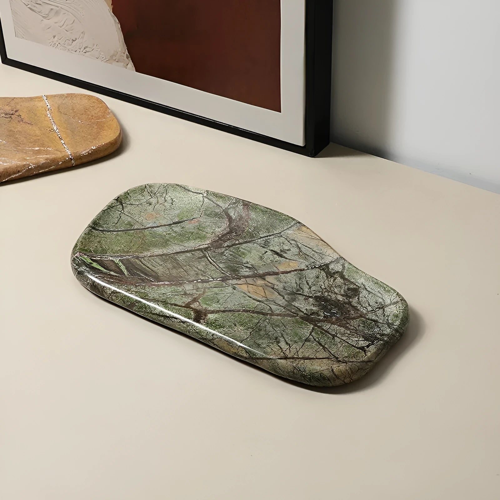 Irregular art marble tray in coffee colour on a wooden table with a plant