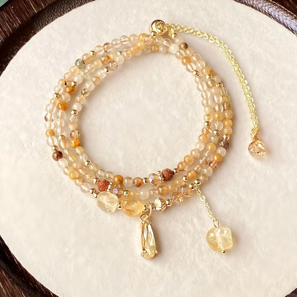 Women's gold natural citrine bracelet with three layered circles and Saturn design details.