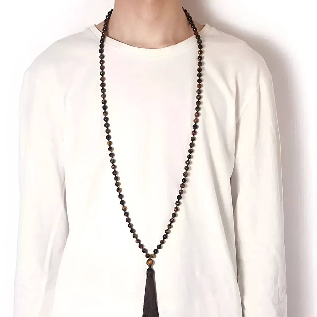 Long blue gemstone tassel necklace with agate, lapis lazuli, and turquoise beads on a geometric pendant.