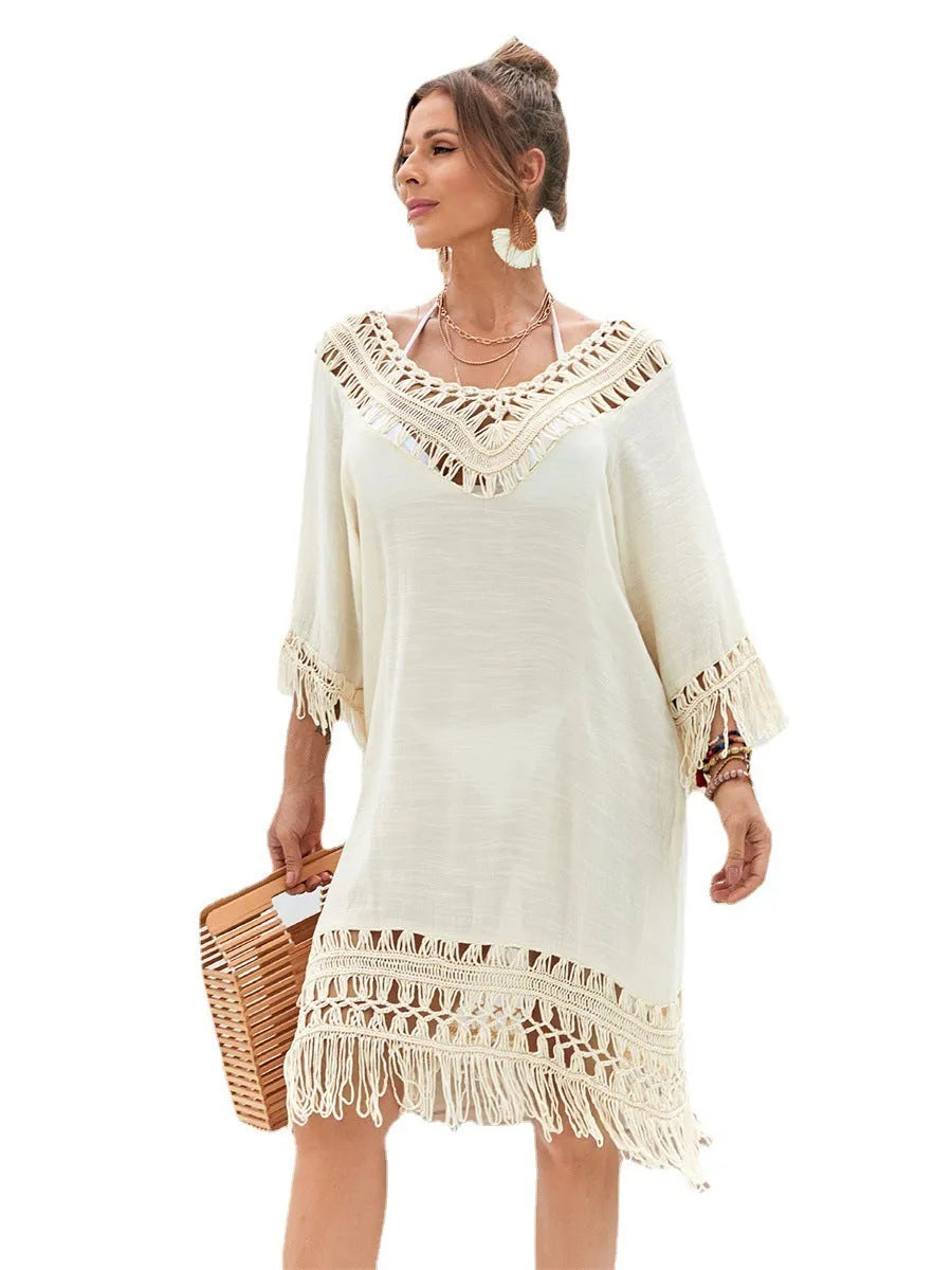 Apricot coloured hand-crocheted acrylic beach dress for women on a hanger.