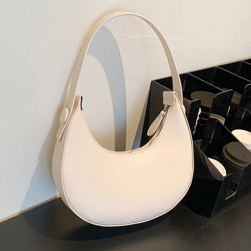 Women's retro dumpling-shaped shoulder bag in PU leather showing internal zipper pocket.