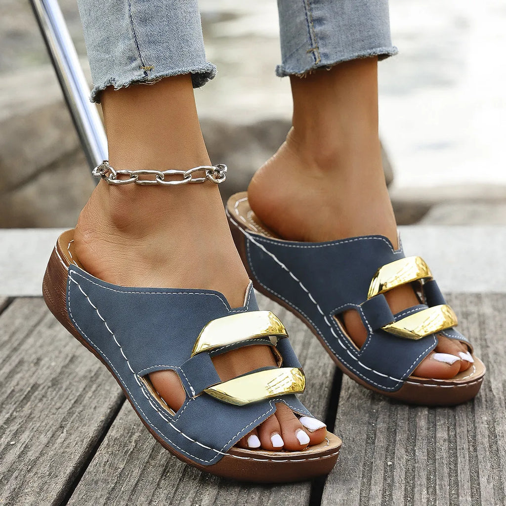 Roman style platform sandals in black, featuring a flat heel, rubber sole, and metallic decorative details.