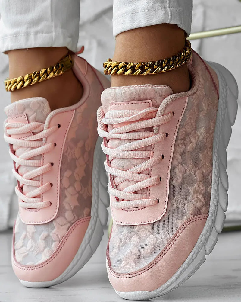 Women's white canvas running shoes with flat heel and round toe on a plain background.