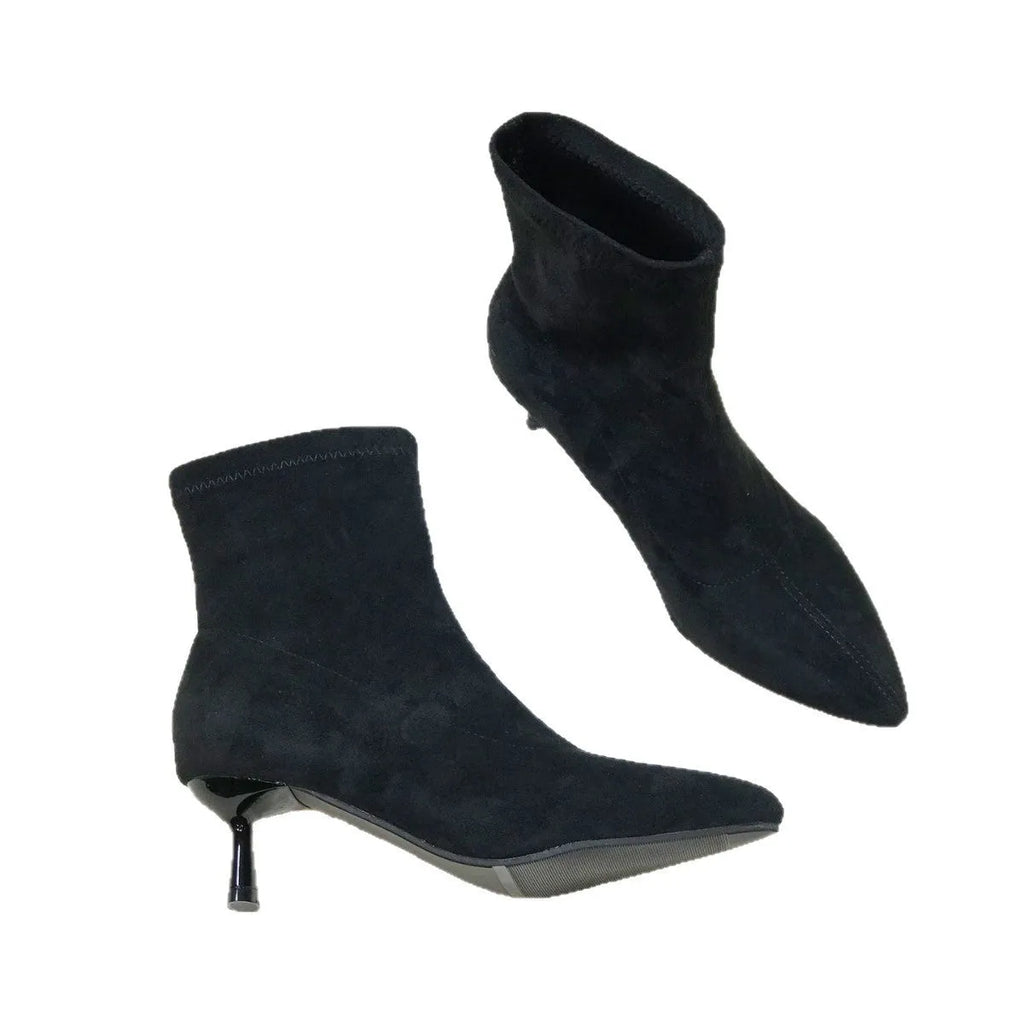 Black pointed toe women's ankle boots with a stiletto heel and mid-calf sock length on a white background