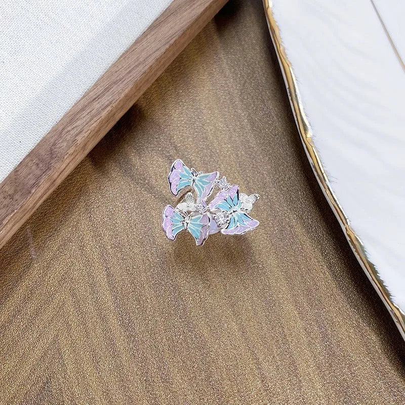 Close-up of an adjustable, irregularly shaped copper ring featuring a detailed insect motif.